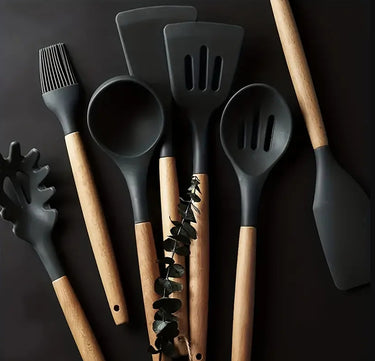 Set of kitchen utensils with black silicone heads and wooden handles on a dark background